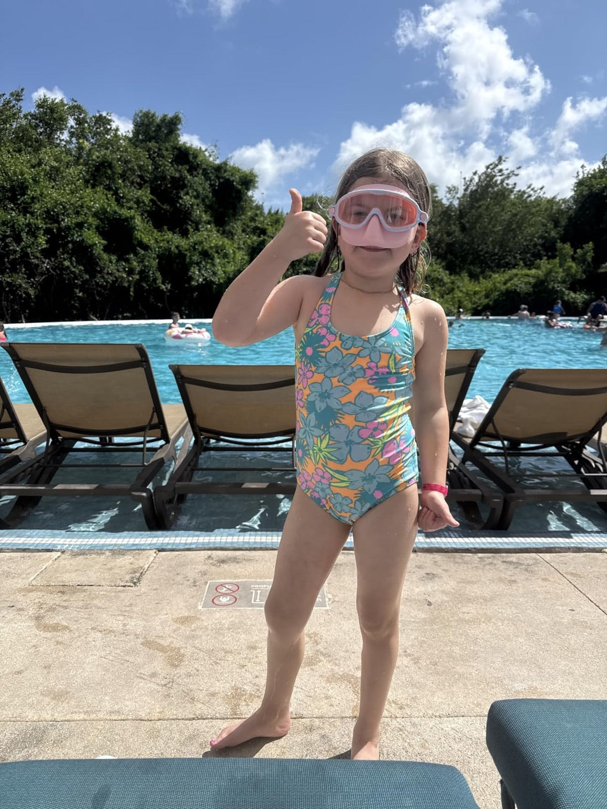 Child wearing pink Vvinca nose-cover goggles at the pool
